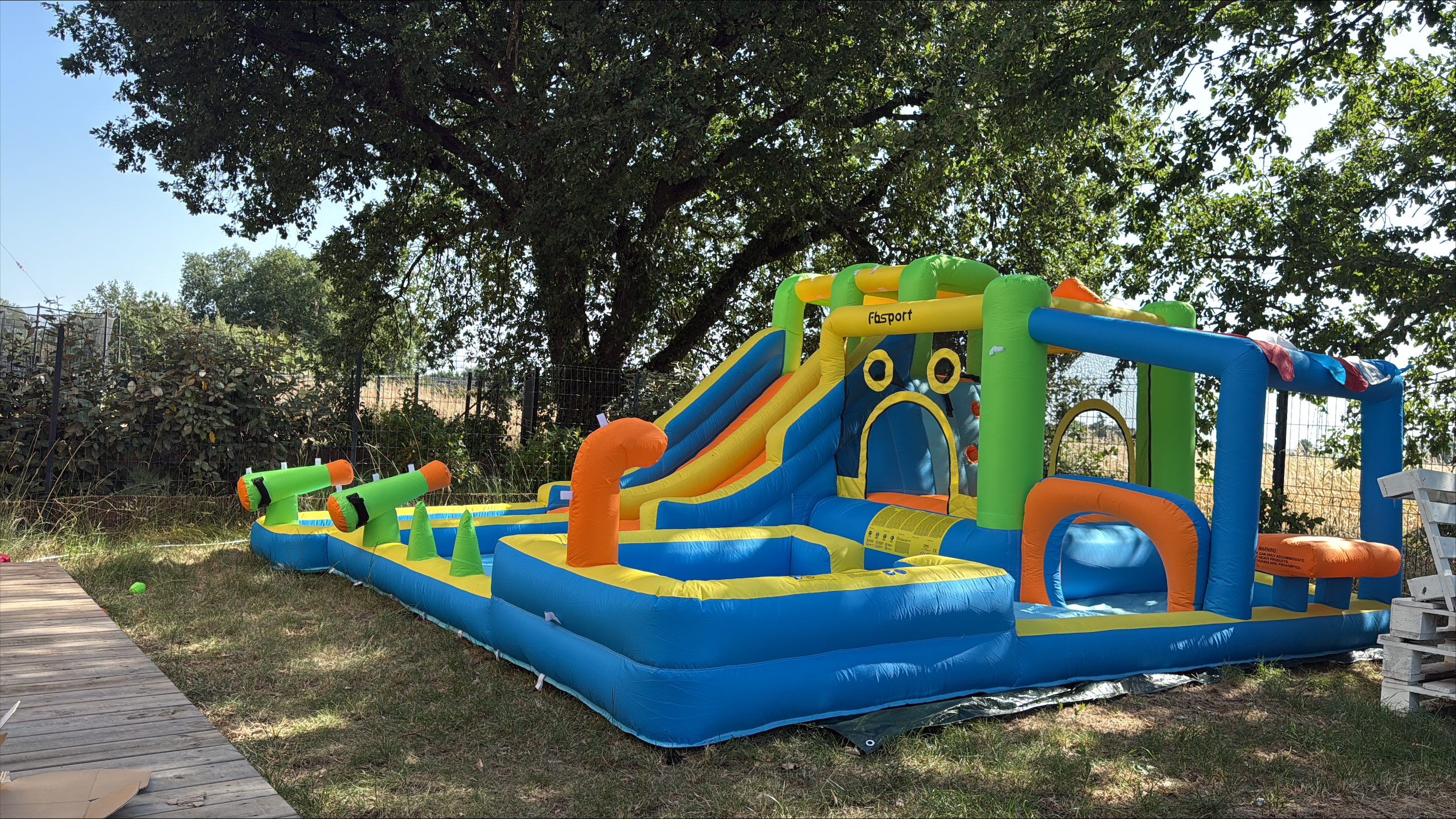 Château gonflable aquatique AquaFun Muret installé dans un jardin